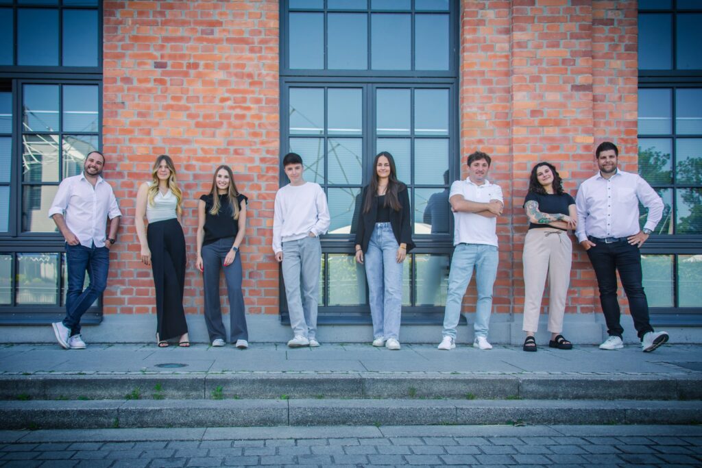 Teamfoto vor Backsteinfassade